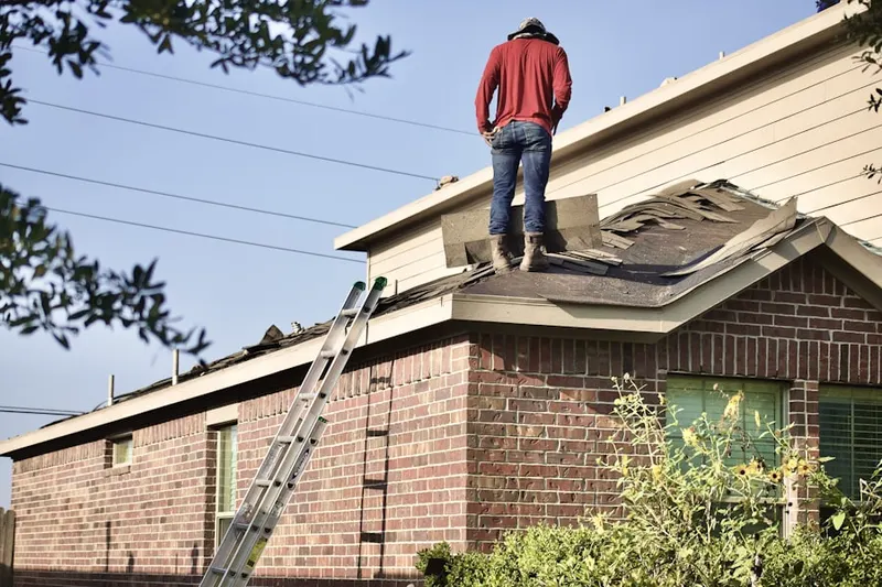 Professional roofer working on a residential roof in De Witt